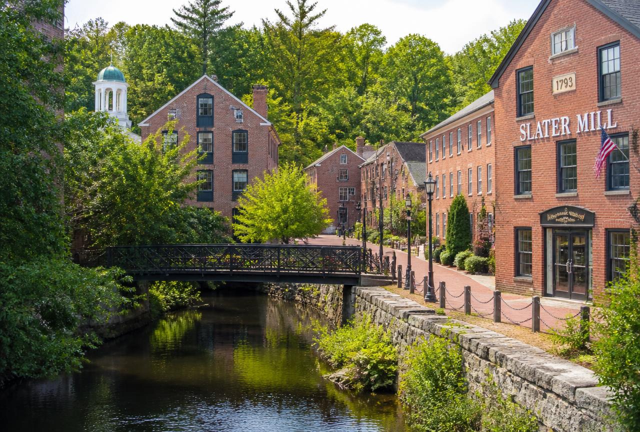 Restored brick mill buildings and footbridge along the Woonasquatucket River in North Providence, Rhode Island
