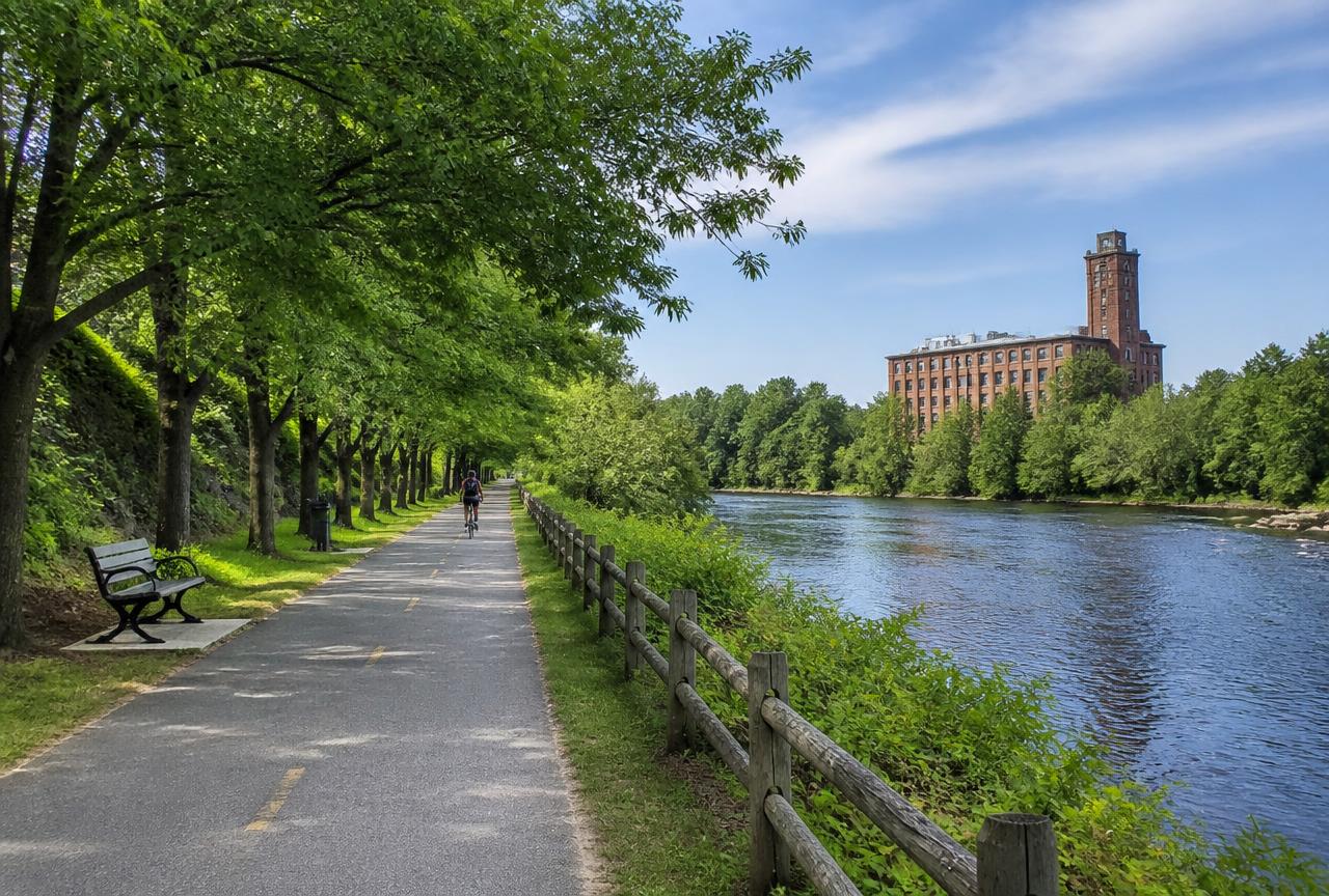 Paved Blackstone River Bikeway path beside the river in Woonsocket, Rhode Island